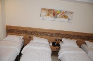 a row of three beds in a hotel room at حديقة الروز in Al Masfalah