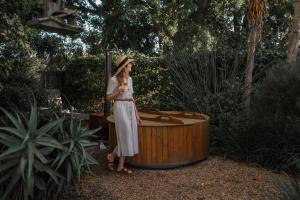 a woman standing in front of a wooden tub at Stellenbosch Farm Cottage with Mountain Views in Stellenbosch +12 photos
