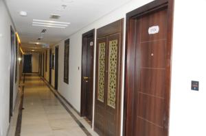 a hallway with wooden doors in a building at حديقة الروز in Al Masfalah