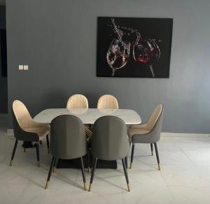 a dining room with a table and four chairs at Max Heights in Ikeja