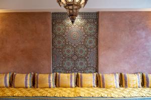 a bedroom with a wall with a chandelier at Villa BALRA une maison d'hôtes au coeur du centre ville in Rabat