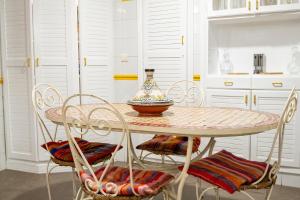 a table with chairs and a vase on top of it at Villa BALRA une maison d'hôtes au coeur du centre ville in Rabat +46 photos