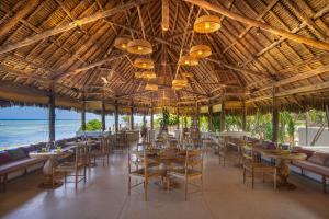 a restaurant with tables and chairs and the ocean at Matemwe Attitude - Adults Only in Matemwe