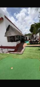 a resort with a putting green and a house at Tourmaline GuestHouse in Windhoek