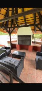 a patio with couches and a table and a fireplace at Tourmaline GuestHouse in Windhoek