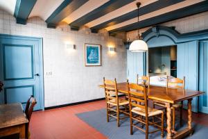 a dining room with a wooden table and chairs at Het Sluiswachtershuisje in Maassluis +11 photos