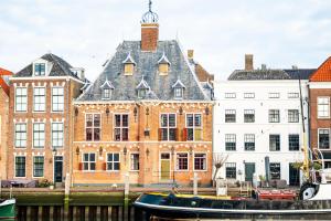 a large building with a black boat in front of it at Het Sluiswachtershuisje in Maassluis
