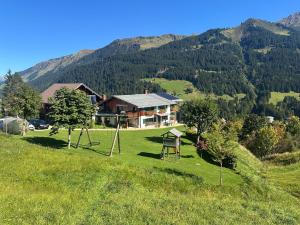 a house on a hill with a playground in a field at Bi-dr-Gondamaika in Hirschegg