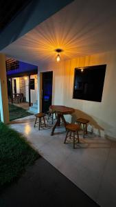 a picnic table and benches on a patio at night at Chalés Boqueirão beach in Japaratinga