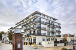 a large white building with a clock in front of it at SEETELHOTEL Kaiserstrand Beachhotel das Lifestyle-Hotel direkt am Strand in Bansin