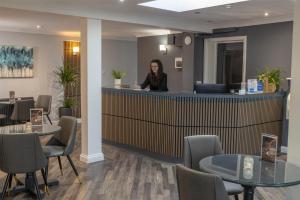 Eine Frau steht an einem Schalter in einem Wartezimmer. in der Unterkunft Best Western Claydon Hotel in Ipswich