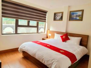 a bedroom with a red and white bed with a window at OnMe in Sapa