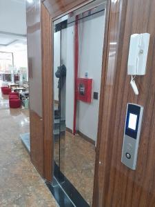 a glass door with a pay phone on a wall at OnMe in Sapa