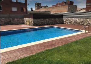 a swimming pool in a yard with a wooden deck at Apartamento con encanto in Igualada