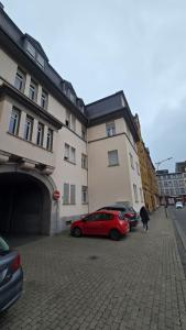 a red car parked in a parking lot next to a building at Altstadtnähe Sauna-Infrarot 2 Schlafzimmer in Koblenz