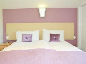 a bedroom with a large bed with two purple pillows at Quixhill - Denstone - Dove Meadow B & B in Uttoxeter
