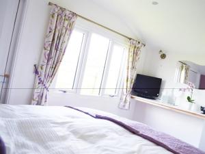a bedroom with a bed and a window at Quixhill - Denstone - Dove Meadow B & B in Uttoxeter