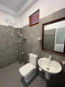 a bathroom with a toilet and a sink and a mirror at Saman Beach Guest House in Galle +64 photos