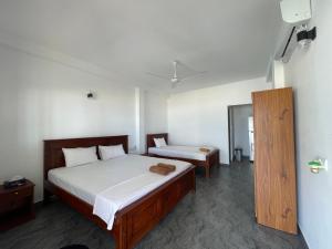 a bedroom with two beds in a room at Saman Beach Guest House in Galle