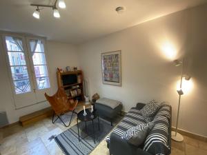 a living room with a couch and a table at Aux 4 FONTAINES in Narbonne