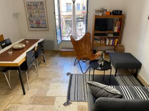 a living room with a table and a dining room at Aux 4 FONTAINES in Narbonne