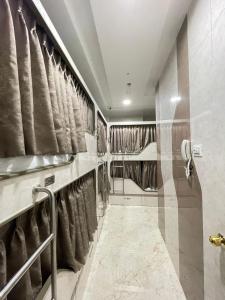 eine ebenerdige Dusche in einem Badezimmer mit Vorhängen in der Unterkunft AVIRAHI HOTEL in Mumbai