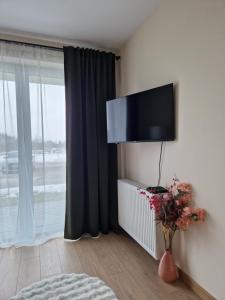 a room with a tv on a wall with a window at Apartament Potockiego Private Parking Faktura in Rzeszów +23 photos