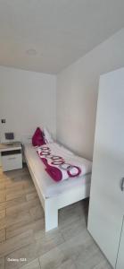 a white bed with red pillows on it in a room at Ilo's Zimmervermietung in Stadtallendorf
