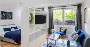 a bedroom with a bed and a couch and a tv at Long Stay Close To Canary Wharf - Business Travelers, Contractors, Small Families in London
