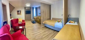 a room with two beds and a couch and a chair at Hotel Benica in Benešov