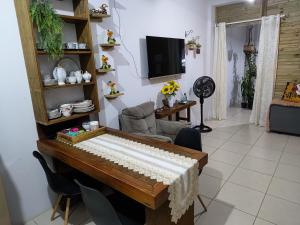 a piano in a living room with a television at Estúdio conceito aberto - 3 pessoas in Araranguá