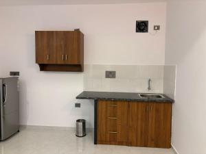 a kitchen with a sink and a refrigerator at Henmil Hideaway in Anjuna