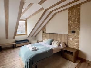 a bedroom with a bed and a stone wall at Atico de lujo en el Pirineo in El Pueyo de Jaca