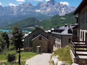 a village with mountains in the background with a street light at Atico de lujo en el Pirineo in El Pueyo de Jaca