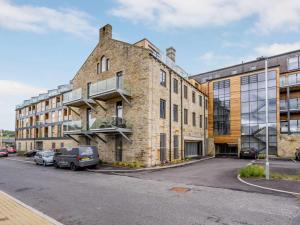 a large brick building with cars parked in front of it at 2 Bed in Keighley oc-83162 in Cononley