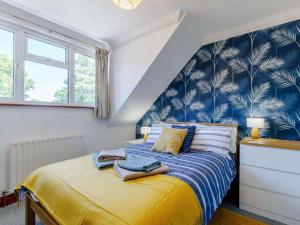 a bedroom with a bed with a blue and white wallpaper at 4 Bed in Southampton oc-82920 in Netley +19 photos