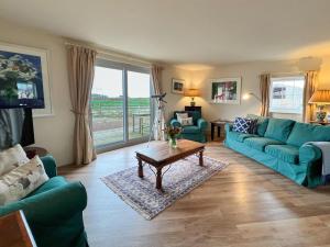 a living room with blue couches and a table at 2 Bed in Mindrum oc-86637 in Carham