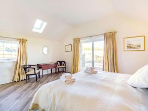 a bedroom with a large bed with a desk and windows at 2 Bed in Mindrum oc-86637 in Carham