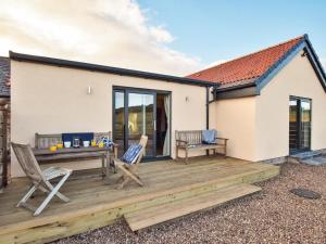 a wooden deck with chairs and a table at 2 Bed in Mindrum oc-86637 in Carham
