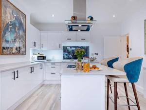 a kitchen with white cabinets and a blue bar stool at 3 Bed in Shanklin oc-92053 in Shanklin