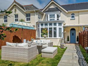 a patio with wicker furniture in front of a house at 3 Bed in Shanklin oc-92053 in Shanklin