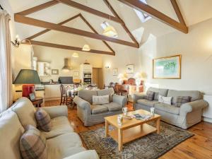 a living room with couches and a table at 4 Bed in Mindrum oc-86272 in Carham