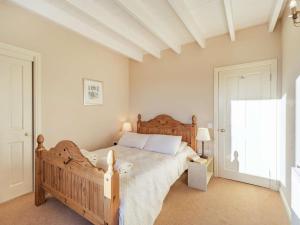 a bedroom with a wooden bed and a window at 4 Bed in Mindrum oc-86272 in Carham