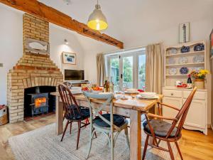 a dining room with a table and a fireplace at 3 Bed in Brockenhurst oc-nfl82 in Beaulieu