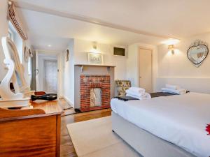 a bedroom with a large bed and a fireplace at 3 Bed in Brockenhurst oc-nfl82 in Beaulieu