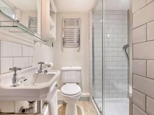 a bathroom with a toilet and a sink and a shower at 3 Bed in Brockenhurst oc-nfl82 in Beaulieu