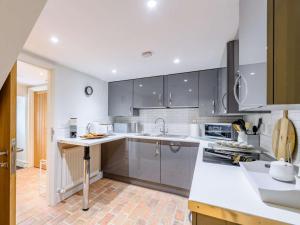 a kitchen with gray cabinets and white counter tops at 2 Bed in Scarborough oc-82543 in Snainton +11 photos