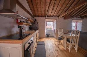 a kitchen with a table and a dining room at Ribeirinha 94 in Ribeirinha