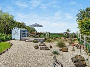 a garden with a small shed and an umbrella at 2 Bed in Belford oc-92196 in Ellington