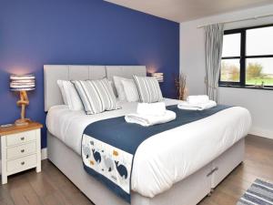 a bedroom with a large bed with a blue wall at 2 Bed in Belford oc-92196 in Ellington